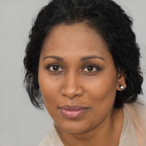 Joyful black young-adult female with long  brown hair and brown eyes