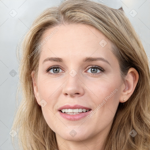 Joyful white young-adult female with long  brown hair and blue eyes