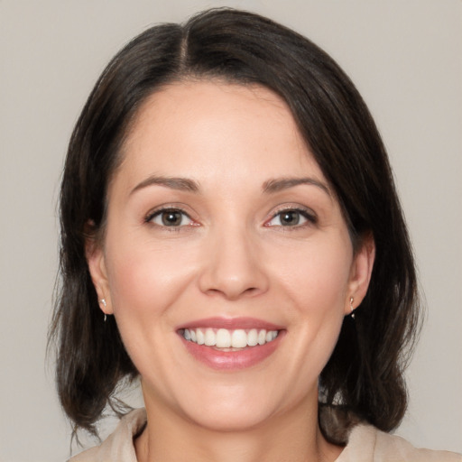 Joyful white adult female with medium  brown hair and brown eyes