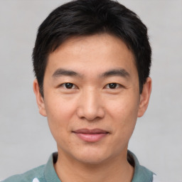 Joyful asian young-adult male with short  black hair and brown eyes