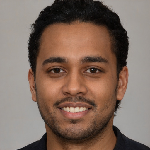 Joyful latino young-adult male with short  black hair and brown eyes