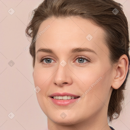 Joyful white young-adult female with medium  brown hair and grey eyes