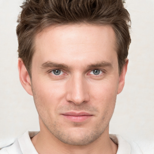 Joyful white young-adult male with short  brown hair and grey eyes