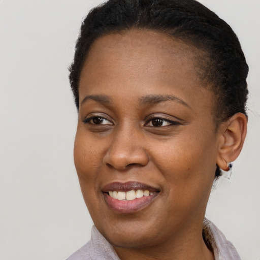 Joyful black young-adult female with short  brown hair and brown eyes