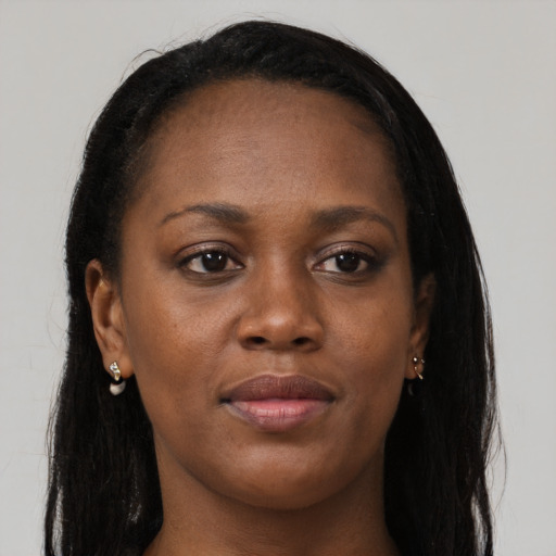 Joyful black young-adult female with long  brown hair and brown eyes