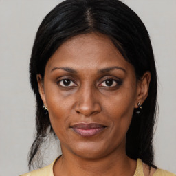 Joyful black adult female with medium  brown hair and brown eyes