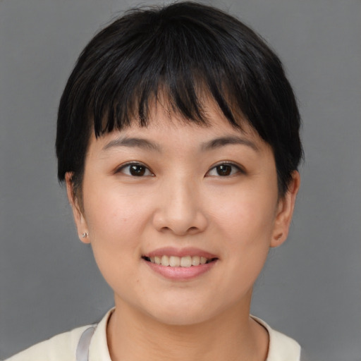 Joyful asian young-adult female with short  brown hair and brown eyes