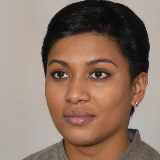 Joyful black young-adult female with short  black hair and brown eyes