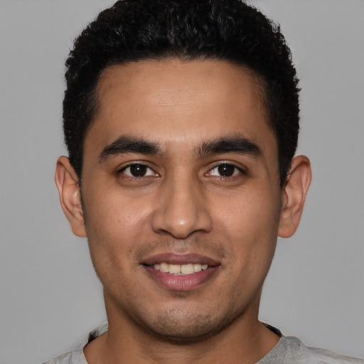 Joyful latino young-adult male with short  black hair and brown eyes