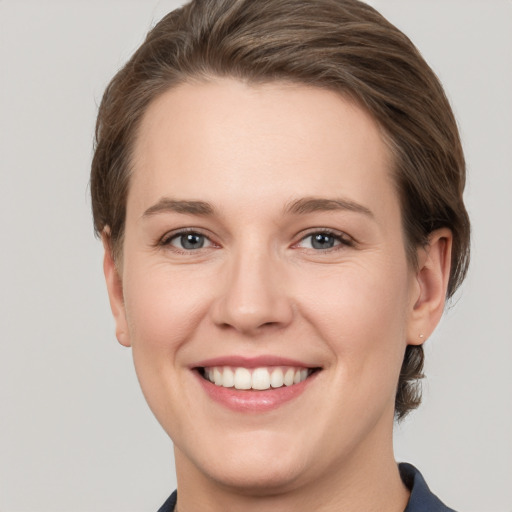 Joyful white young-adult female with short  brown hair and grey eyes