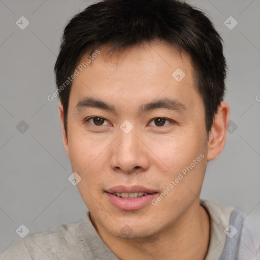 Joyful asian young-adult male with short  brown hair and brown eyes