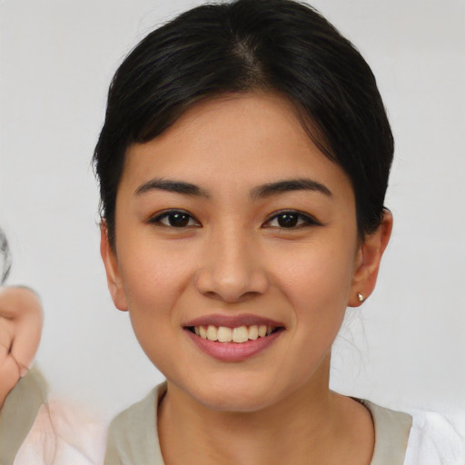 Joyful asian young-adult female with short  black hair and brown eyes