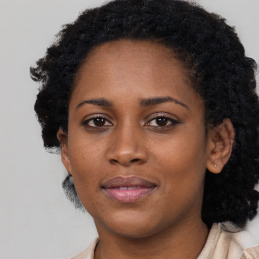Joyful black young-adult female with short  black hair and brown eyes