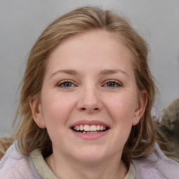 Joyful white young-adult female with medium  brown hair and blue eyes