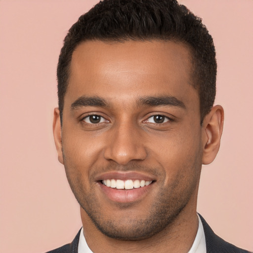 Joyful black young-adult male with short  brown hair and brown eyes