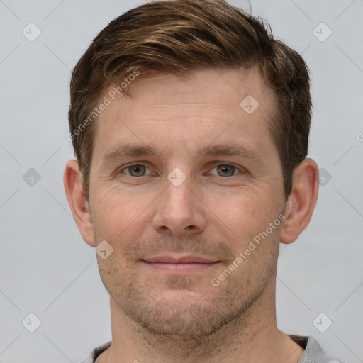 Joyful white young-adult male with short  brown hair and grey eyes