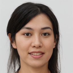 Joyful asian young-adult female with long  brown hair and brown eyes