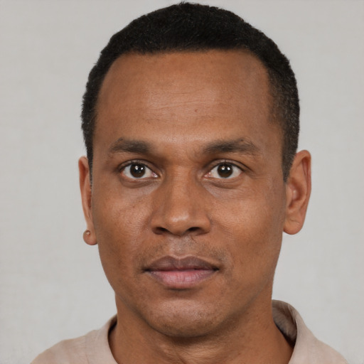 Joyful black young-adult male with short  black hair and brown eyes