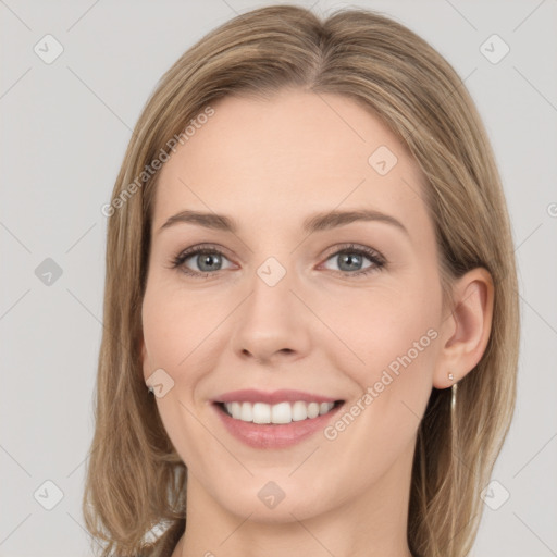 Joyful white young-adult female with long  brown hair and green eyes