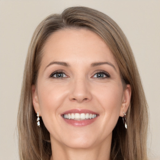 Joyful white adult female with long  brown hair and grey eyes