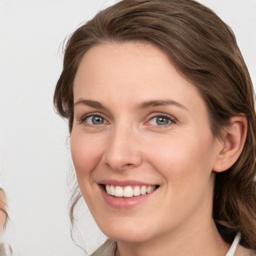 Joyful white young-adult female with medium  brown hair and blue eyes