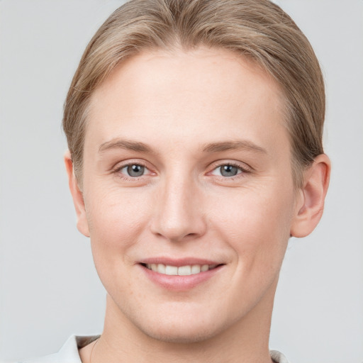 Joyful white young-adult female with short  brown hair and grey eyes