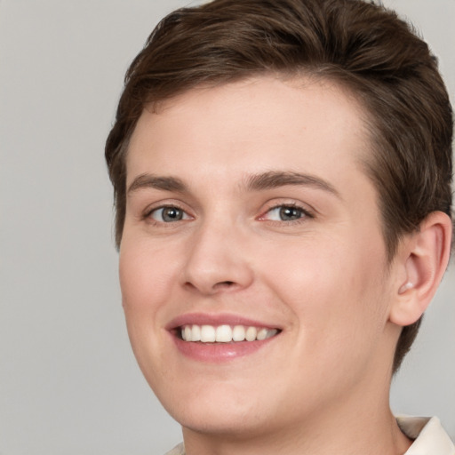 Joyful white young-adult female with short  brown hair and grey eyes