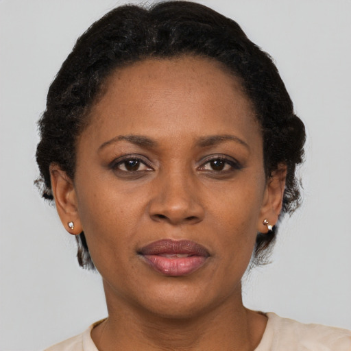 Joyful black adult female with short  black hair and brown eyes