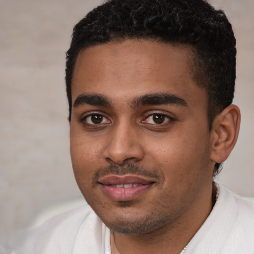 Joyful black young-adult male with short  black hair and brown eyes