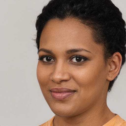 Joyful black young-adult female with short  brown hair and brown eyes