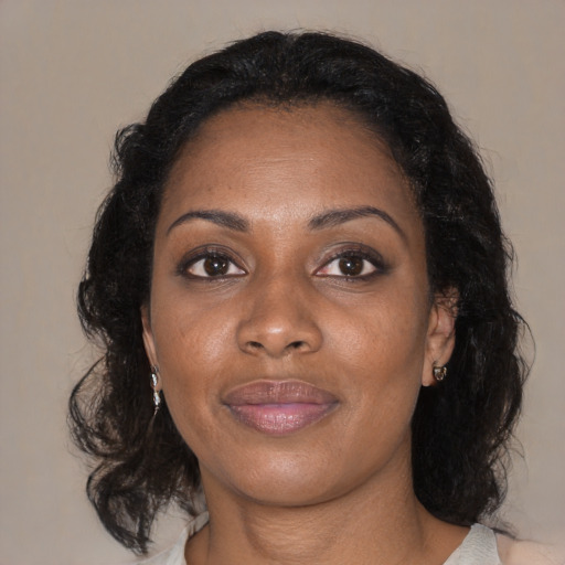 Joyful black adult female with medium  brown hair and brown eyes