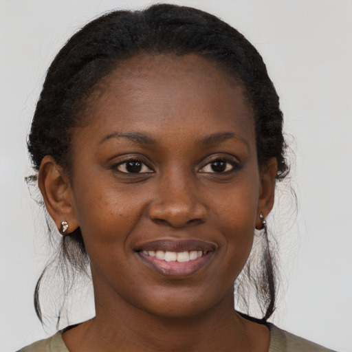 Joyful black young-adult female with long  brown hair and brown eyes