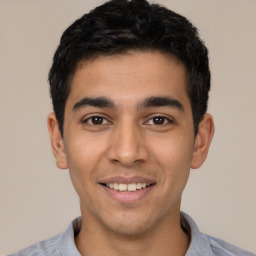 Joyful latino young-adult male with short  black hair and brown eyes