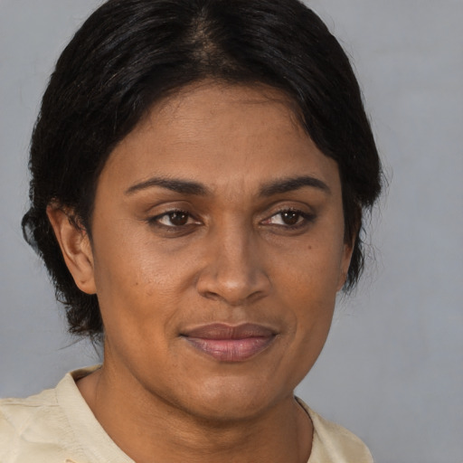 Joyful latino adult female with medium  brown hair and brown eyes