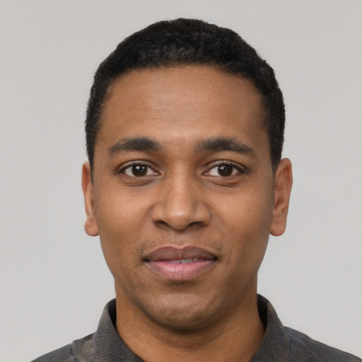 Joyful black young-adult male with short  black hair and brown eyes