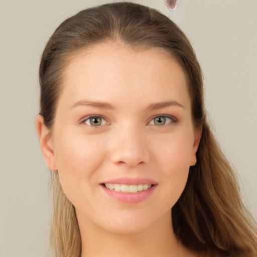 Joyful white young-adult female with long  brown hair and blue eyes