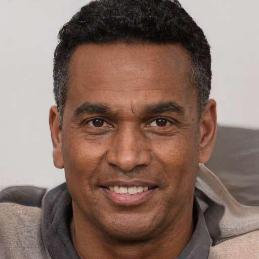 Joyful black adult male with short  black hair and brown eyes