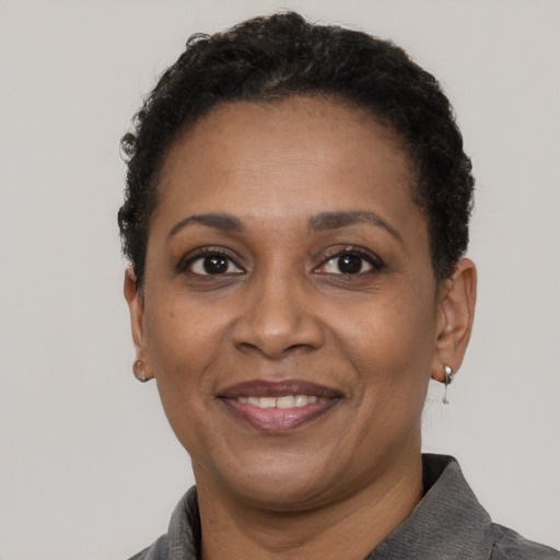 Joyful black adult female with short  black hair and brown eyes