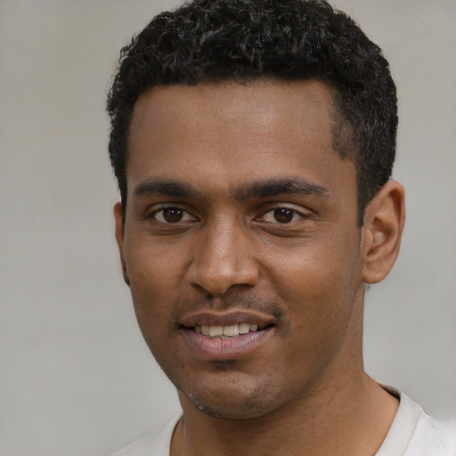 Joyful black young-adult male with short  black hair and brown eyes