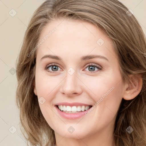 Joyful white young-adult female with long  brown hair and blue eyes