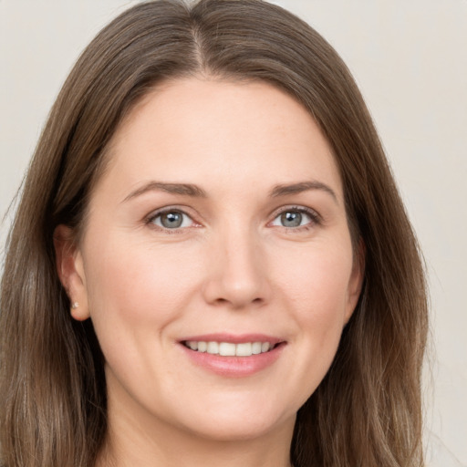 Joyful white young-adult female with long  brown hair and grey eyes