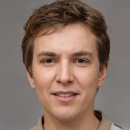 Joyful white young-adult male with short  brown hair and grey eyes