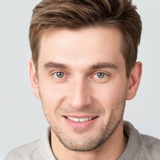 Joyful white young-adult male with short  brown hair and grey eyes