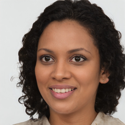 Joyful black young-adult female with long  brown hair and brown eyes