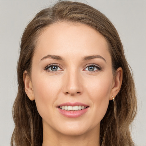 Joyful white young-adult female with long  brown hair and grey eyes