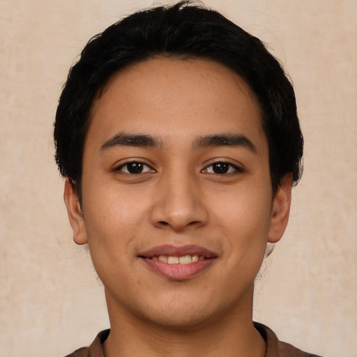 Joyful latino young-adult male with short  black hair and brown eyes