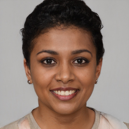 Joyful black young-adult female with short  black hair and brown eyes