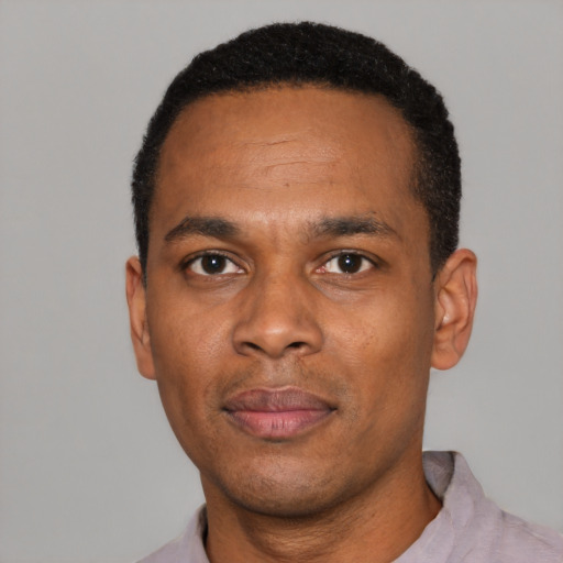 Joyful black young-adult male with short  black hair and brown eyes
