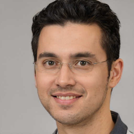 Joyful white adult male with short  black hair and brown eyes