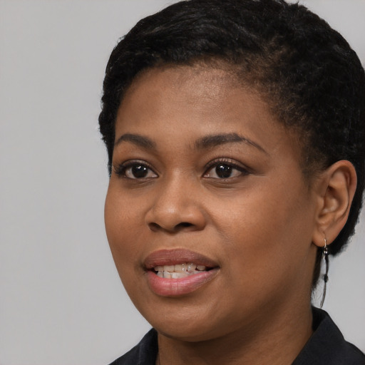 Joyful black young-adult female with short  black hair and brown eyes